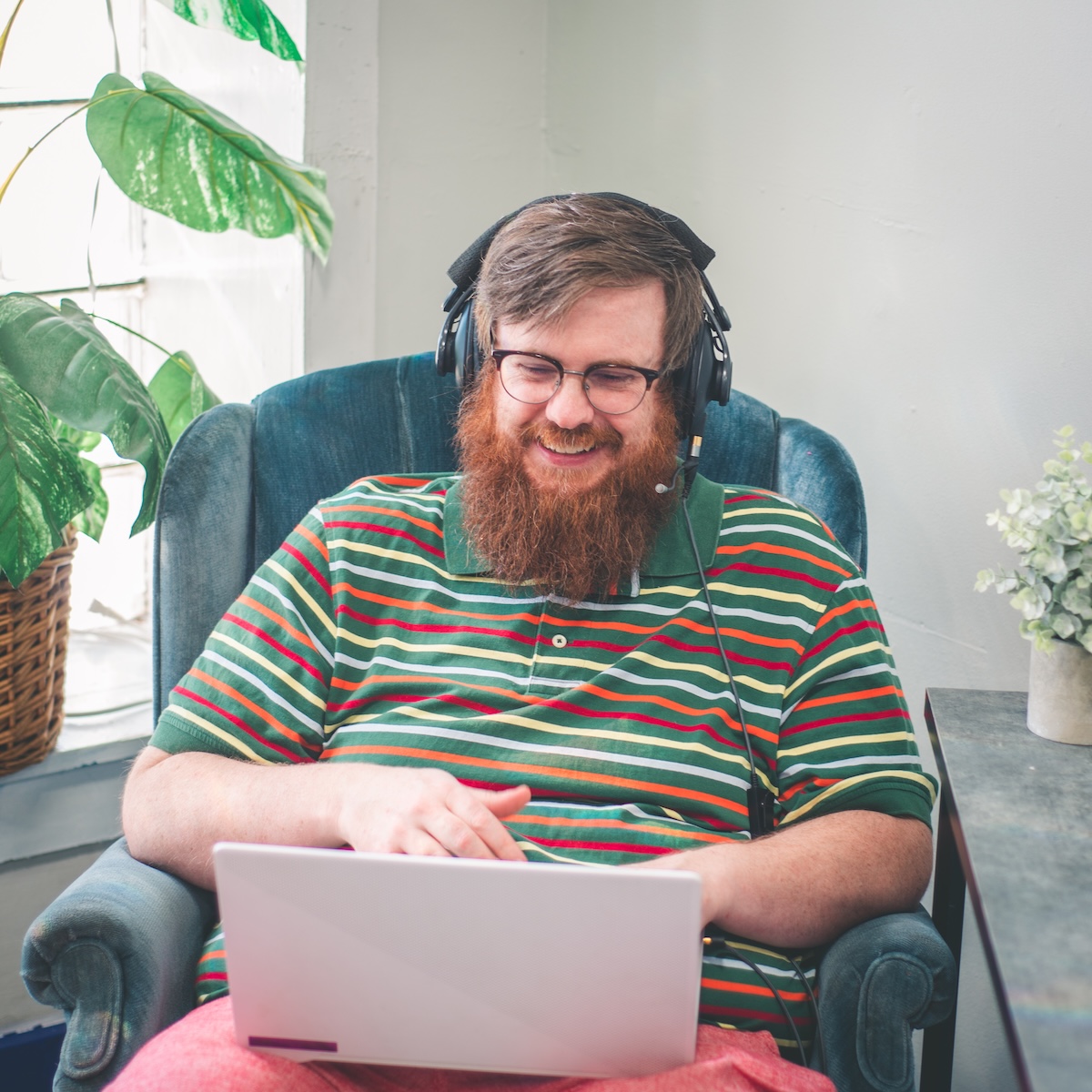 Adam, founder of Atom Systems, smiling while working on his laptop